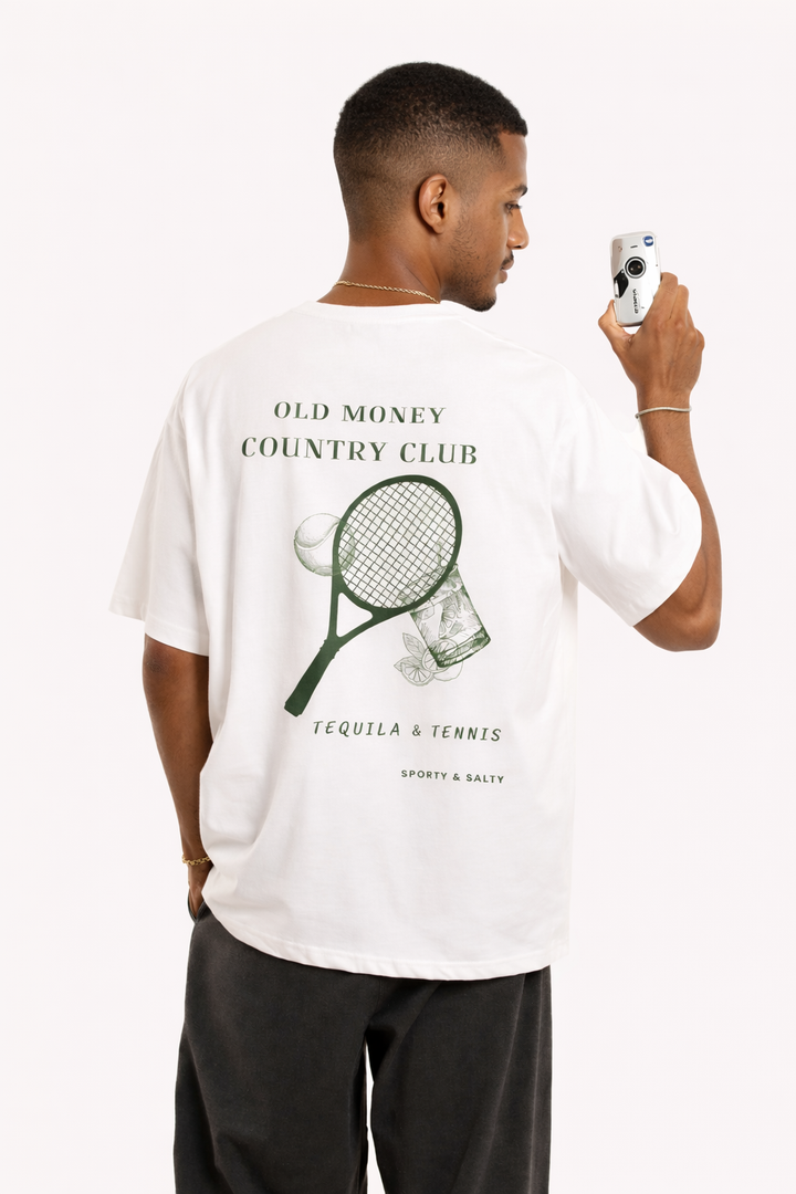 Man wearing a white t-shirt with a graphic design and text, holding a phone.