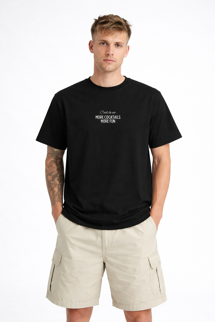 Man wearing a black t-shirt with text and beige shorts on a white background