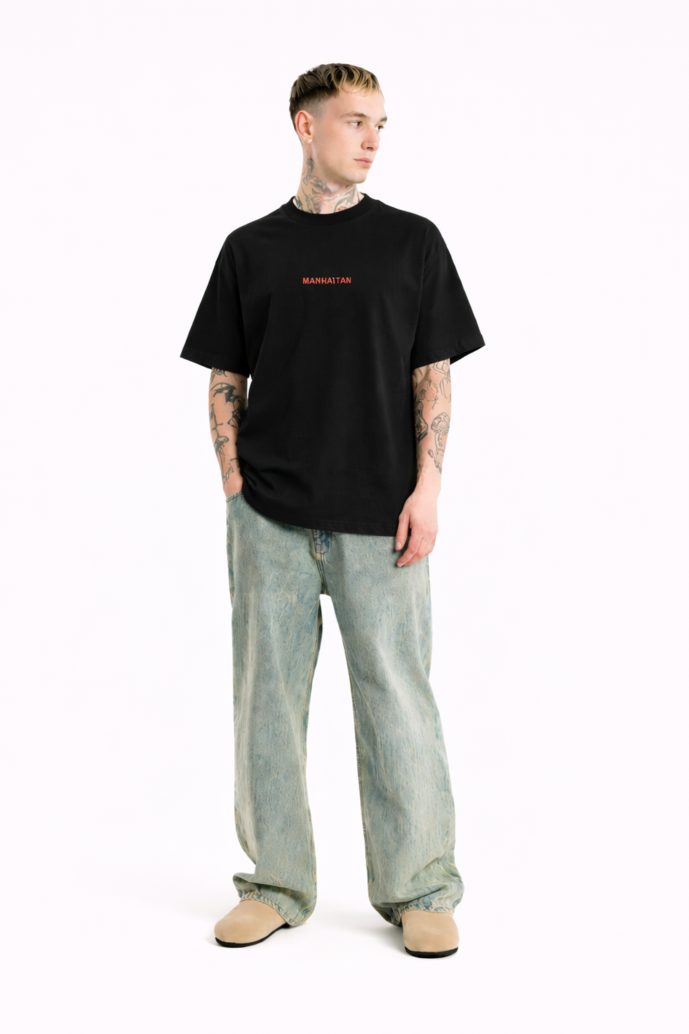 Person wearing a black t-shirt with red text and light blue jeans on a white background