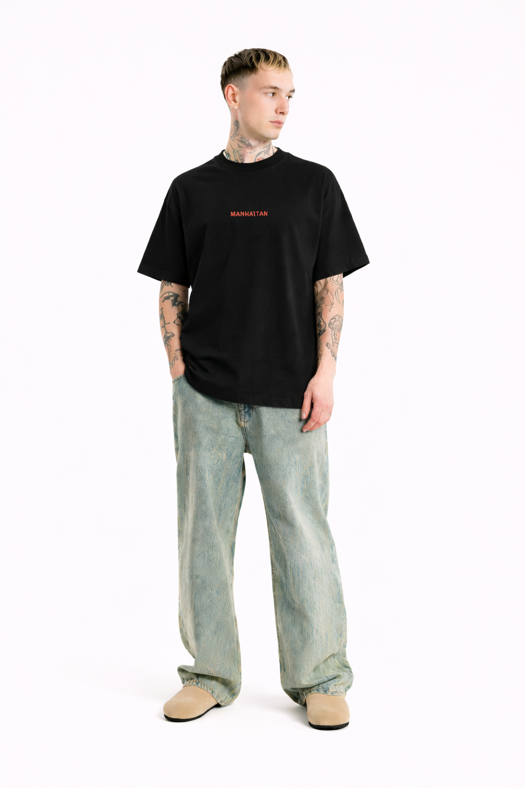 Person wearing a black t-shirt with red text and light blue jeans on a white background