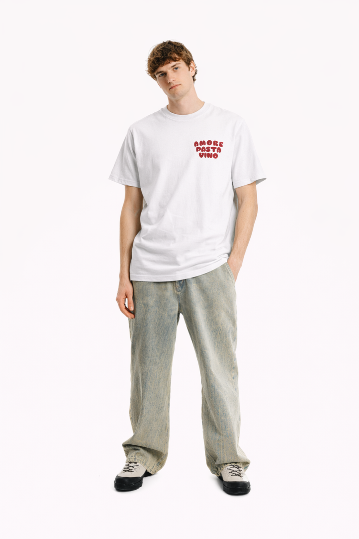 Person wearing a white t-shirt with text and light gray pants on a white background