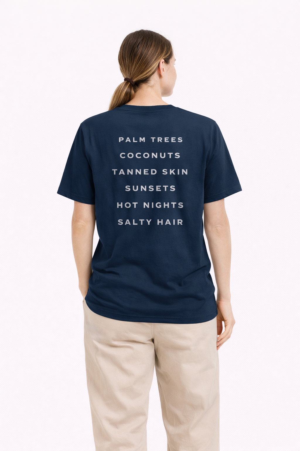 Person wearing a navy blue t-shirt with text on the back, standing against a white background