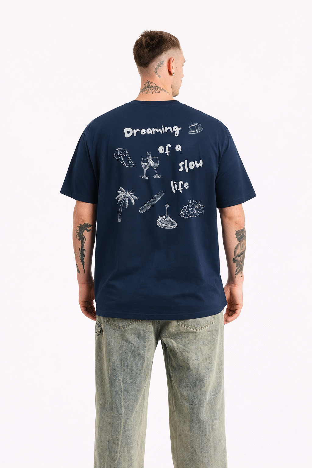 Man wearing a navy blue t-shirt with graphics and text on the back, standing against a white background.