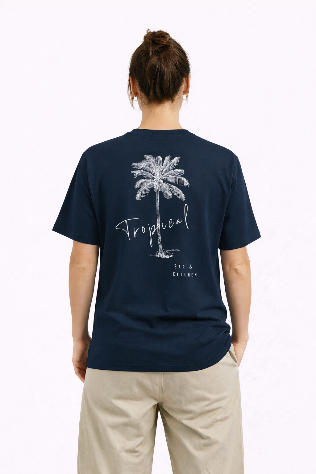 Person wearing a navy blue t-shirt with a palm tree design and 'Tropical' text on the back.