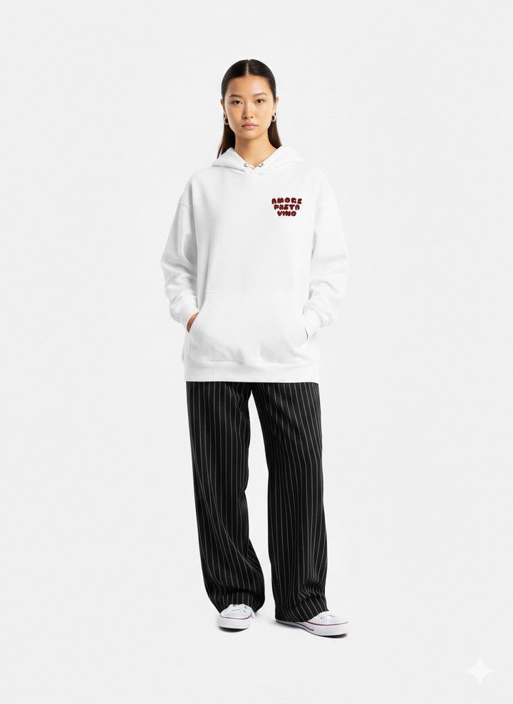 Person wearing a white hoodie with text and black pinstripe pants on a white background