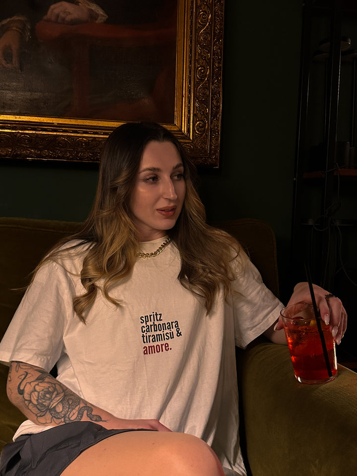 A model wearing the Love from Italy Organic T-shirt, holding a drink and showcasing Italian charm.