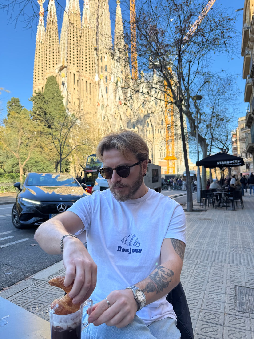 Man eating a pastry with a cathedral in the background