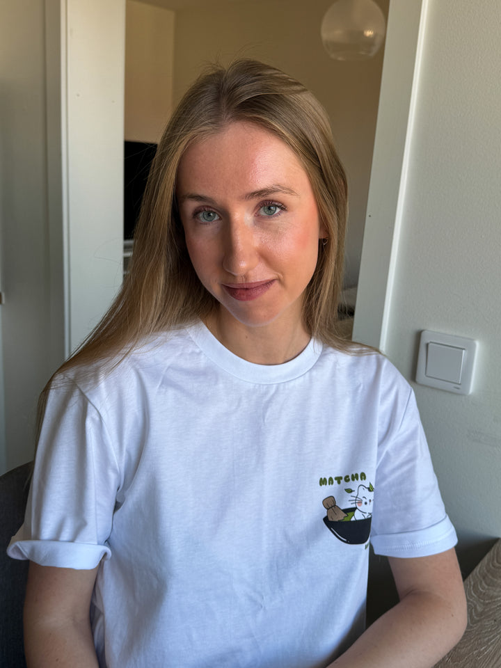 Woman wearing a white t-shirt with a logo in an indoor setting