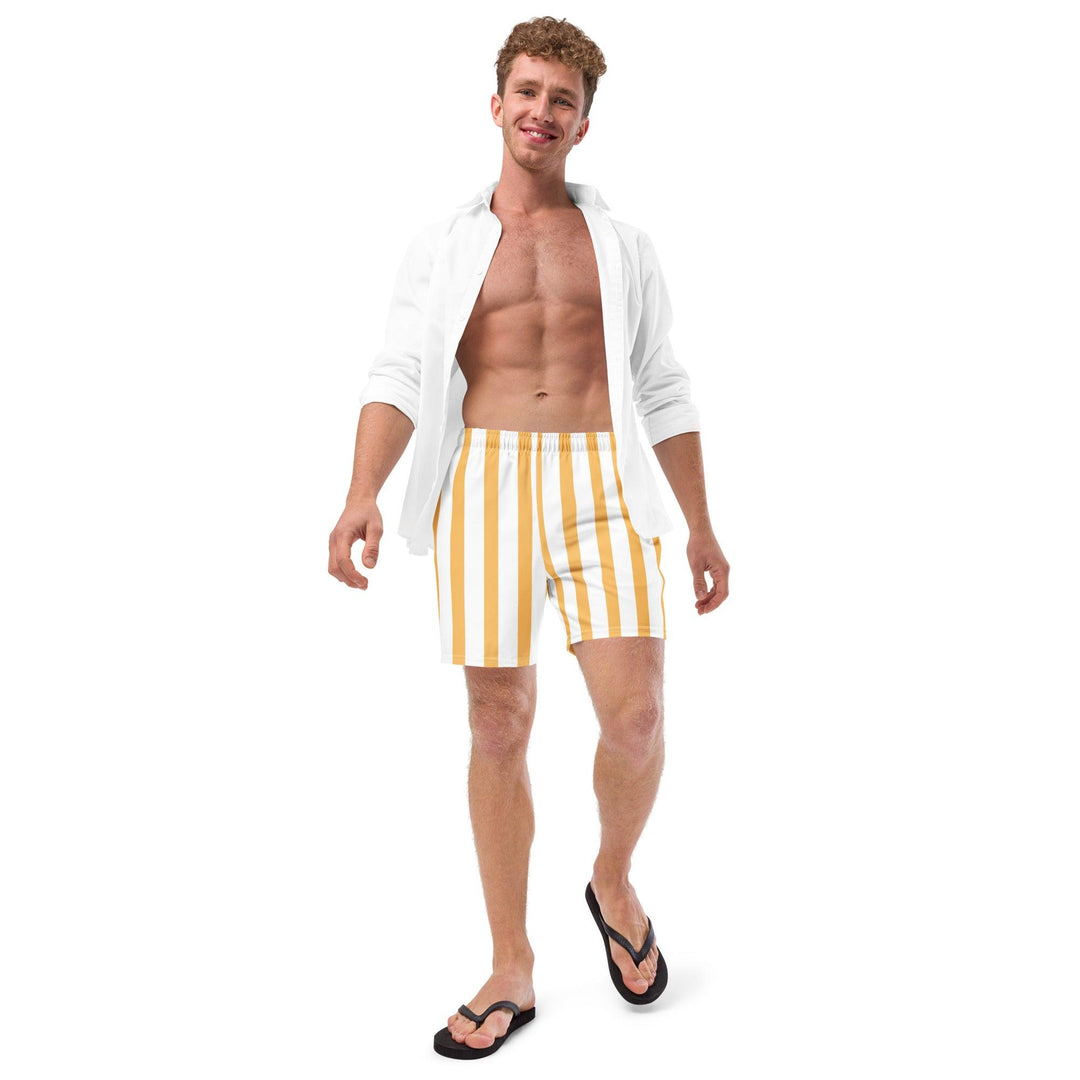 Model wearing yellow and white striped swim trunks, paired with a white open shirt and flip-flops, eco-friendly, by Tequila & Sunrise.