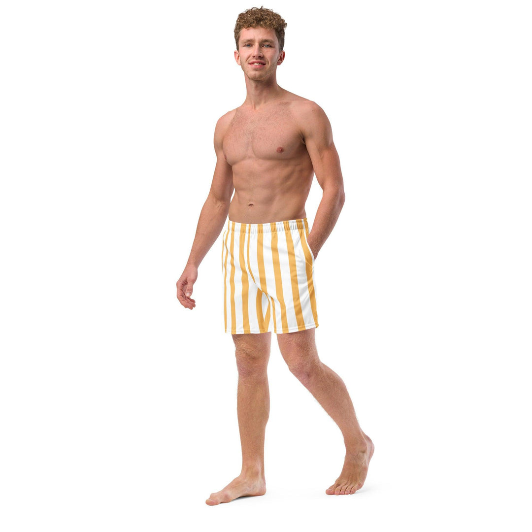 Model wearing yellow and white striped eco-friendly swim trunks, with his one hand in his pocket, by Tequila & Sunrise.