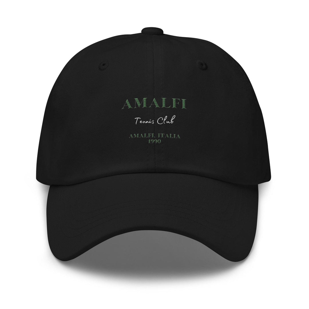 The Amalfi Tennis Club Italia Hat by Tequila & Sunrise is a black Dad hat showcasing "Amalfi Tennis Club" and "Amalfi, Italia 1990" intricately embroidered in green and white on the front. Crafted from chino cotton twill, it includes an adjustable strap for an ideal fit.