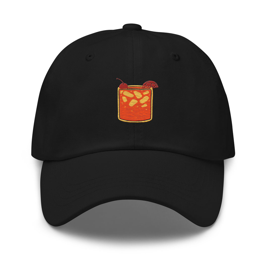 The Tequila & Sunrise Glass Hat by Tequila & Sunrise is a black dad hat featuring an embroidered design of an orange drink with ice cubes and a straw on the front. With its low-profile design and adjustable strap, it combines style and comfort, perfect for any casual outing.