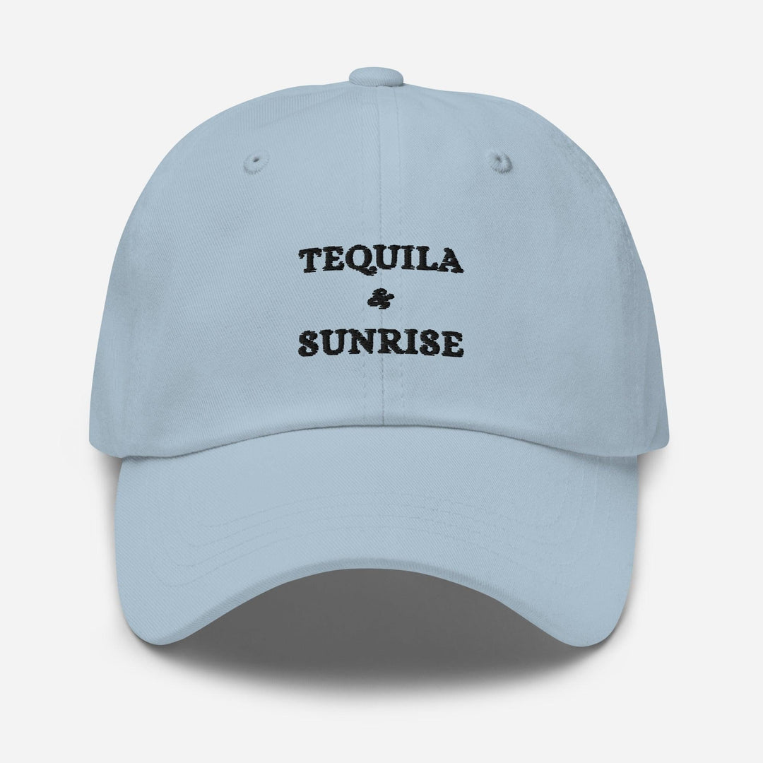 The Tequila & Sunrise Hat by Tequila & Sunrise is a light blue dad hat with the brand's logo embroidered in black on the front and features an adjustable strap for a comfortable fit.