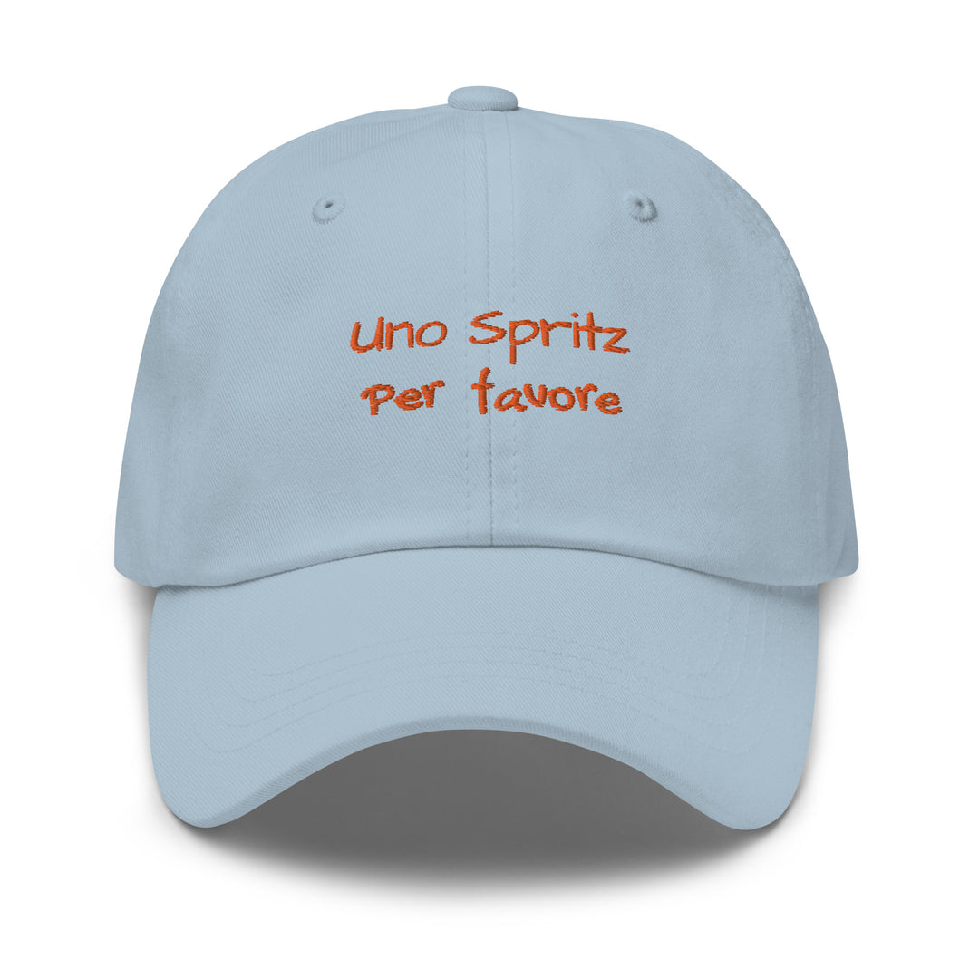 The Uno Spritz Per Favore by Tequila & Sunrise is a light blue dad hat crafted from chino cotton twill, showcasing orange text that reads "uno spritz per favore." It features an adjustable strap for a perfect fit.