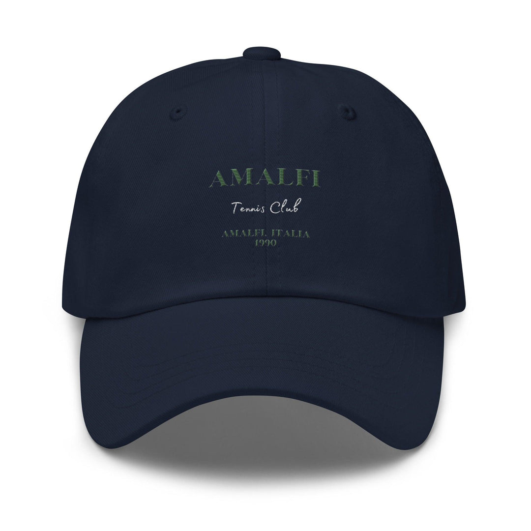 Introducing The Amalfi Tennis Club Italia Hat by Tequila & Sunrise, a dark blue Dad hat showcasing "AMALFI Tennis Club AMALFI, ITALIA 1990" beautifully embroidered in green and white on the front. Constructed from chino cotton twill, it ensures a perfect fit with its adjustable strap.