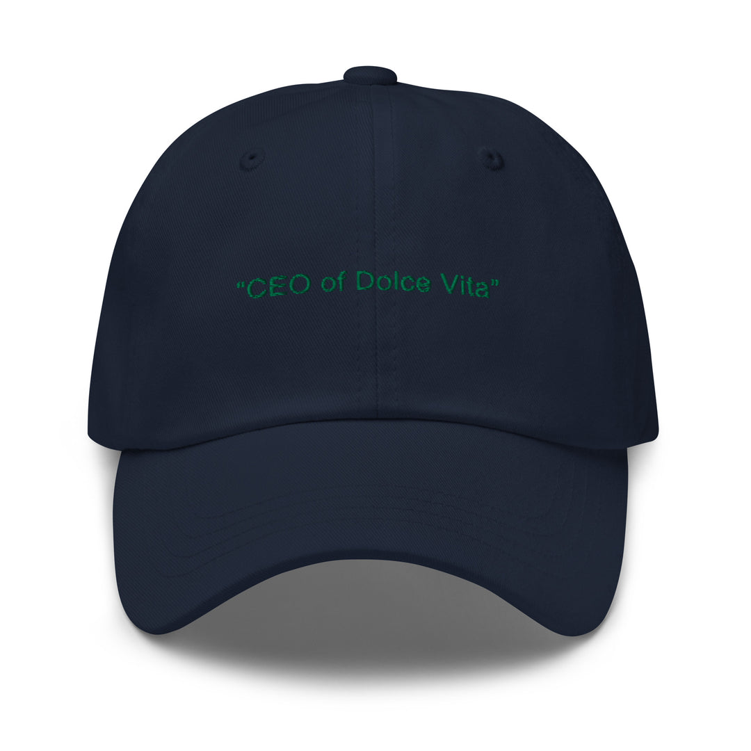 The CEO of Dolce Vita Hat from Tequila & Sunrise is a dark blue dad hat with a low-profile design. It features the embroidered text "CEO of Dolce Vita" in green on the front and comes with an adjustable strap for a comfortable fit.