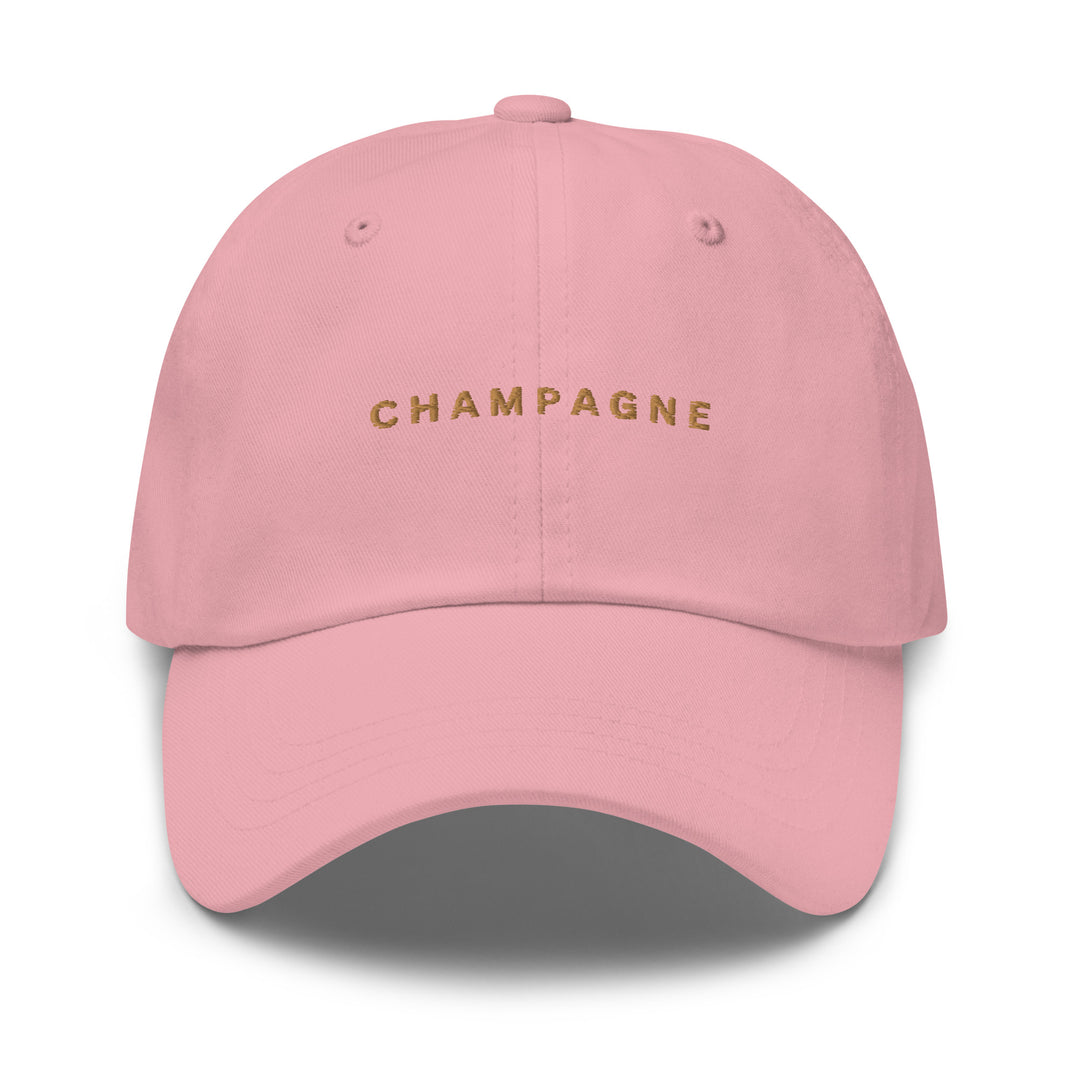 The Champagne Dad Hat by Tequila & Sunrise comes in a soft pink chino cotton twill and features "CHAMPAGNE" embroidered in gold on the front. This stylish hat includes an adjustable strap for the perfect fit and maximum comfort.