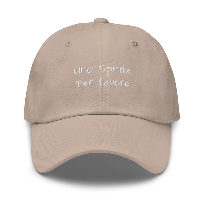 The Uno Spritz Per Favore by Tequila & Sunrise is a stone dad hat crafted from chino cotton twill, showcasing white text that reads "uno spritz per favore." It features an adjustable strap for a perfect fit.