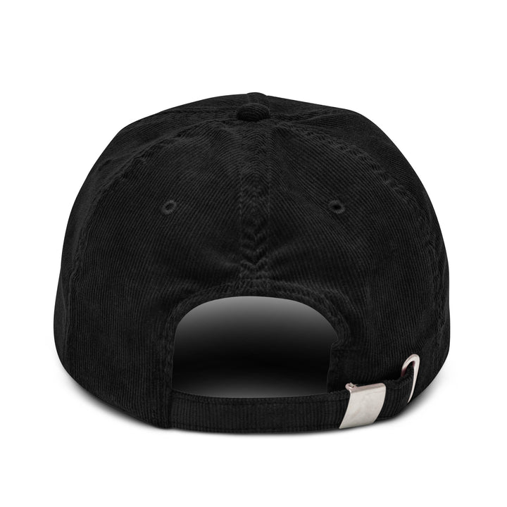 The back view of The Champagne Please Corduroy Hat by Tequila & Sunrise showcases a black cotton corduroy baseball cap with an adjustable strap and a sleek metal buckle.