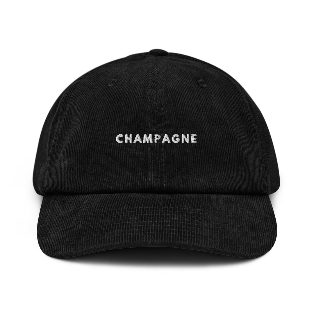 The Champagne Corduroy hat by Tequila & Sunrise features a black cotton design with CHAMPAGNE elegantly embroidered in white on the front and an adjustable buckle for a perfect fit.