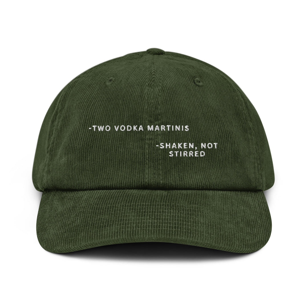 Introducing The Shaken, not Stirred James Bond Quote Corduroy Hat by Tequila & Sunrise: This dark green cotton corduroy baseball cap features the phrase "Two Vodka Martinis - Shaken, Not Stirred" embroidered in white on the front. It comes with an adjustable buckle to ensure a comfortable fit.