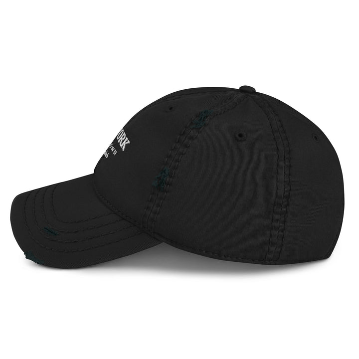 The Tequila & Sunrise New York Downtown Athletic Club Hat is a black dad hat with a distressed brim and seams, made from pre-shrunk cotton twill. It features a white logo and text on the side.