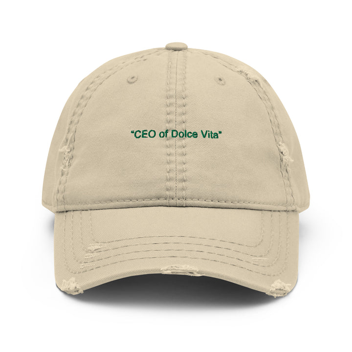 The CEO of Dolce Vita Hat by Tequila & Sunrise is a beige cotton twill dad hat with a distressed brim and green "CEO of Dolce Vita" embroidery on the front.