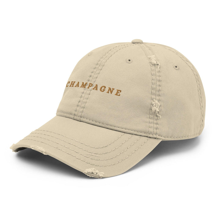 The Champagne Hat by Tequila & Sunrise is a beige dad hat adorned with an embroidered Champagne design on the front, featuring distressed detailing on the brim and panels for an added touch of casual sophistication.