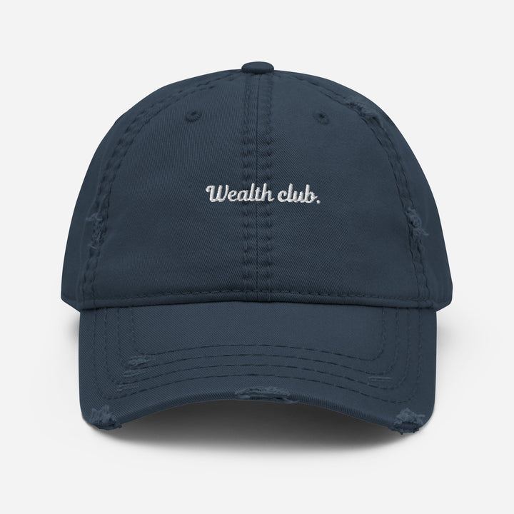 Introducing The Wealth Club Hat by Tequila & Sunrise, a stylish navy distressed dad hat featuring the word Wealth Club. elegantly embroidered in white on the front. This cap includes subtle distressing on the brim and panels, making it a chic addition to any sophisticated wardrobe.