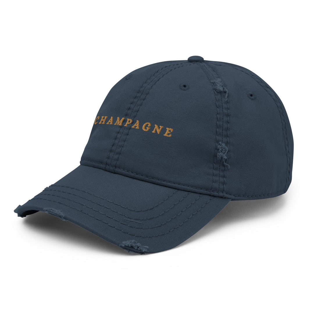 The Champagne Hat from Tequila & Sunrise is a dark green dad hat showcasing the word CHAMPAGNE embroidered in yellow on the front. It features a subtle Champagne design and distressed details, adding a touch of edge to any sophisticated wardrobe.