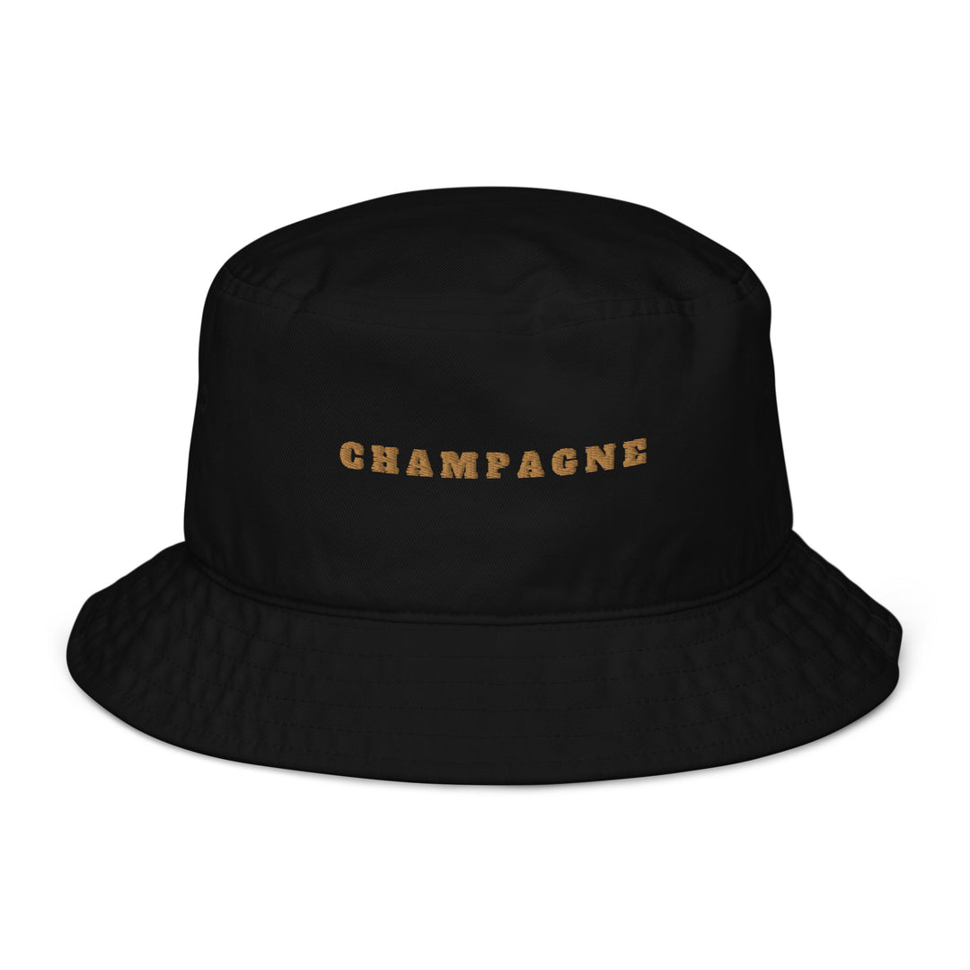 The Champagne Organic Bucket Hat by Tequila & Sunrise is crafted from 100% organic cotton, featuring "CHAMPAGNE" embroidered in gold letters on the front for a stylish and eco-friendly look.