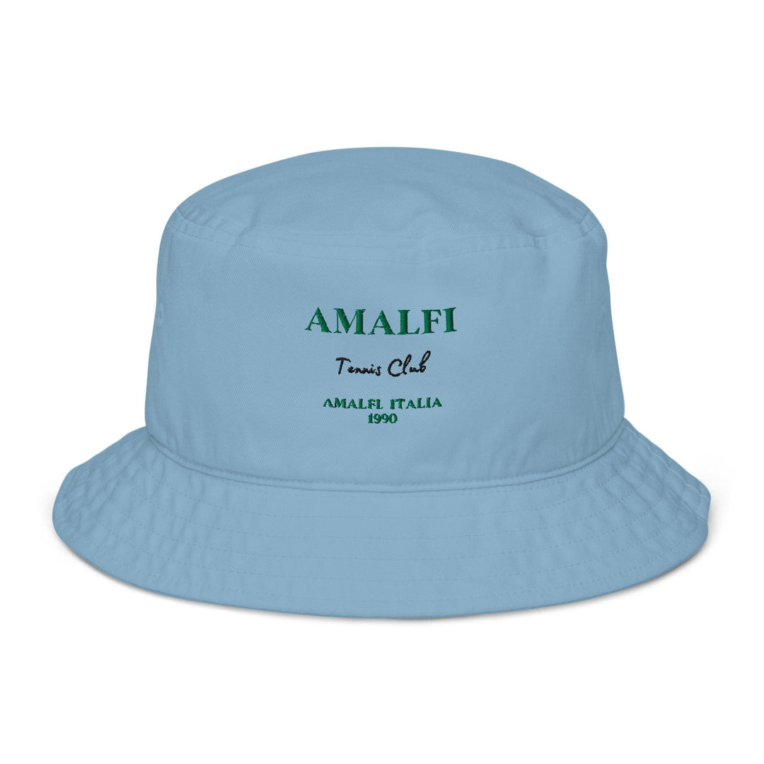 The Amalfi Italia Organic Bucket Hat by Tequila & Sunrise is light blue and features "Amalfi Tennis Club" embroidered in green with "Amalfi Italia 1990" underneath. It's an ideal choice for sun protection while exploring the picturesque Amalfi Coast.