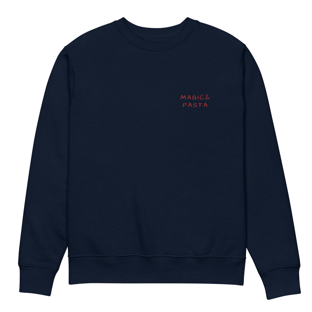 Introducing The Magic & Pasta Eco Sweatshirt by Tequila & Sunrise, a navy blue unisex apparel featuring small red "Magic & Pasta" text elegantly placed on the upper left side of the chest. Crafted from organic cotton, it stands out against a white background.