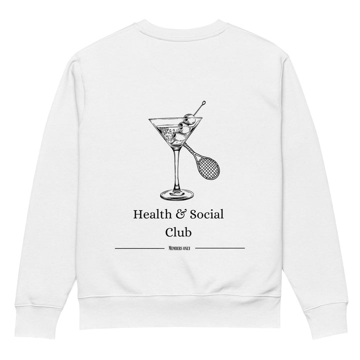 The Health & Social Club Eco Sweatshirt by Tequila & Sunrise features a black line drawing of a martini glass containing a tennis racket and ball. Beneath the illustration, the text "Health & Social Club" is written, followed by "Members only." This made-to-order sweatshirt combines durability with comfort and style.