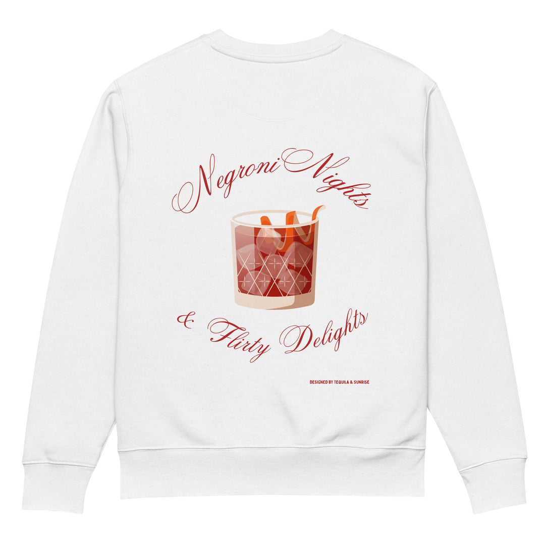 The Negroni Nights & Flirty Delights Eco Sweatshirt by Tequila & Sunrise is a white unisex sweatshirt made from organic cotton, featuring a stylish illustration of a Negroni cocktail with an orange peel garnish. The elegantly scripted text "Negroni Nights & Flirty Delights" encircles the glass, showcasing sustainable fashion.