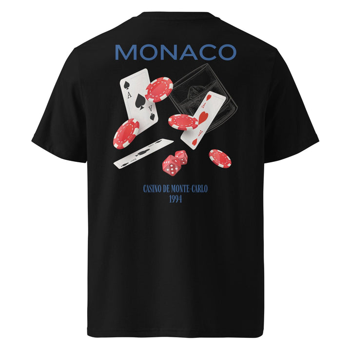 The Tequila & Sunrise Monaco Casino de Monte-Carlo Organic T-shirt is a unisex black tee made from eco-friendly organic cotton, featuring the text "Monaco and Casino de Monte-Carlo 1994." The back is adorned with a vibrant graphic displaying playing cards, poker chips, and dice.