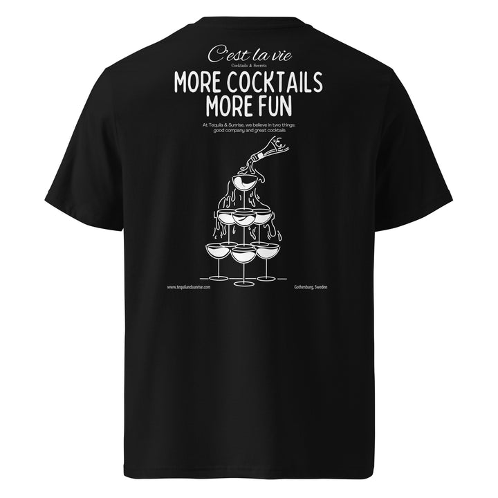 The "The More Cocktails More Fun Organic T-shirt" from Tequila & Sunrise is a unisex black t-shirt crafted from organic cotton, showcasing a stacked champagne glass illustration with the phrase "More Cocktails, More Fun" in white text above.