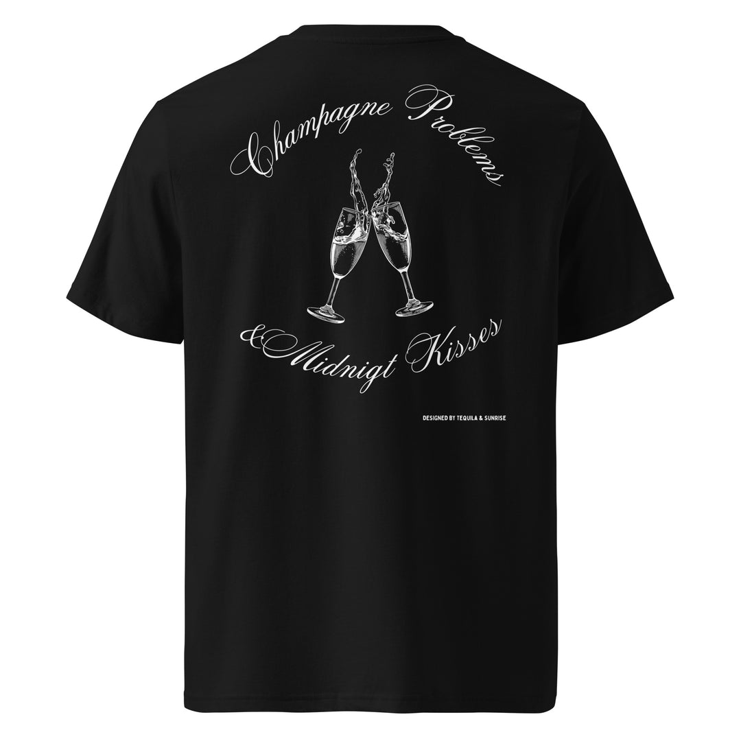 Champagne Problems & Midnight Kisses Organic T-shirt featuring two champagne glasses illustration on a black background.