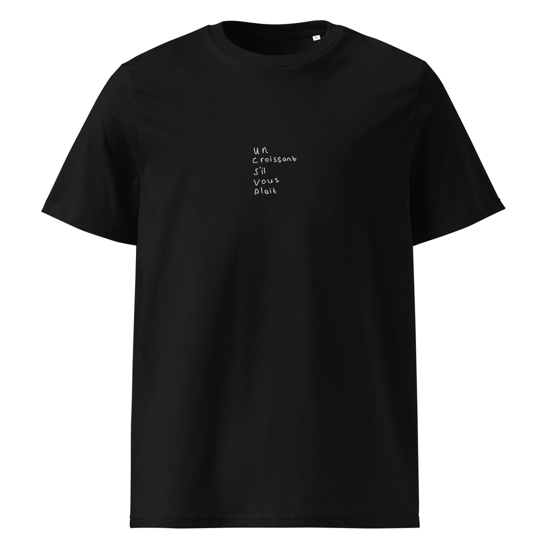 The Tequila & Sunrise "The Un Croissant S’il Vous Plait Organic T-shirt" is an eco-friendly, unisex black cotton shirt featuring the French phrase "Un croissant s'il vous plaît" printed in small white letters on the front, combining style and sustainability.