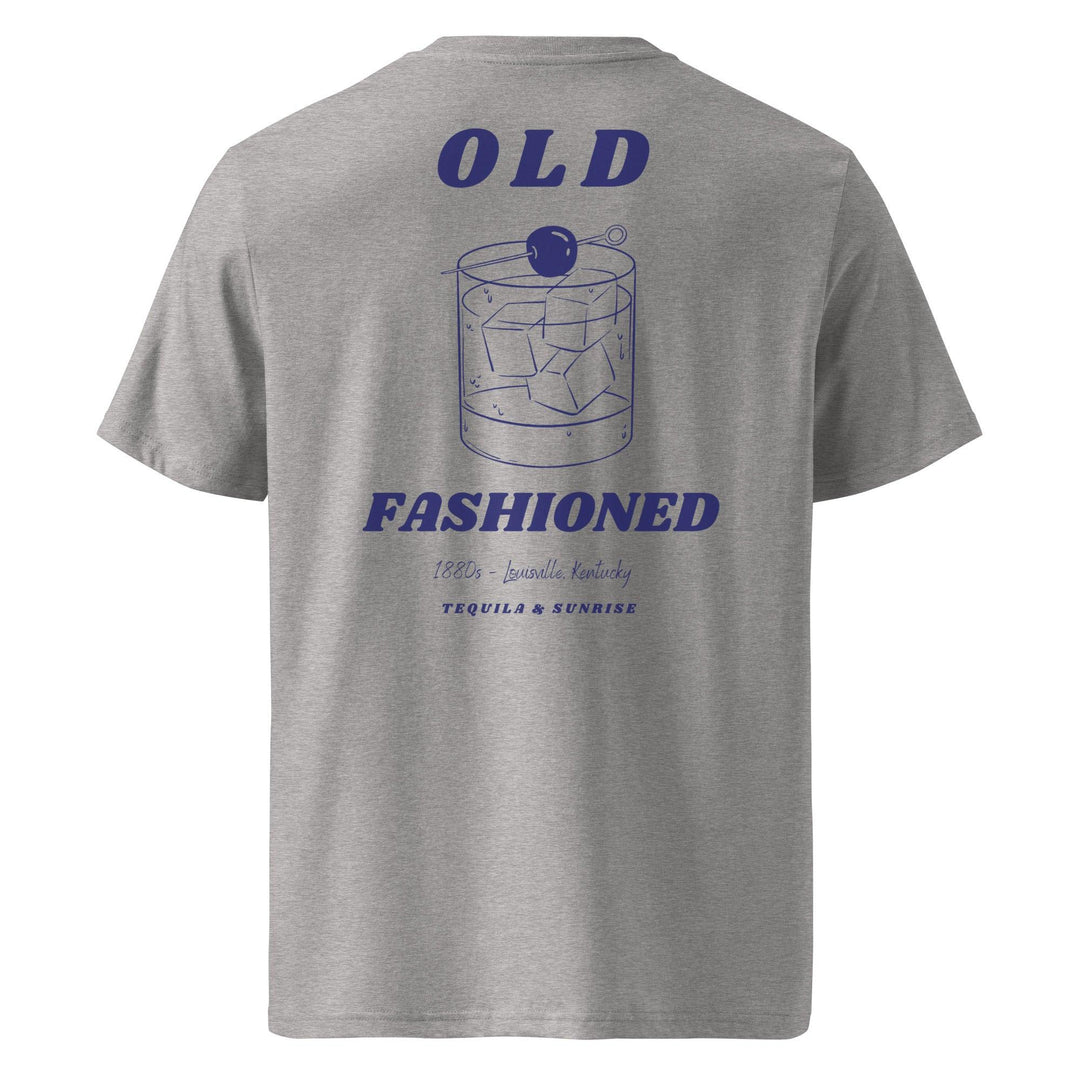 Introducing The Old Fashioned Organic T-shirt by Tequila & Sunrise: This eco-friendly gray graphic tee showcases a stylish design featuring an Old Fashioned cocktail glass adorned with ice and a cherry. Crafted from organic cotton, it prominently displays the bold text "OLD FASHIONED" with elegant script details beneath.