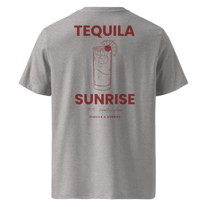 The Tequila & Sunrise Organic T-shirt by Tequila & Sunrise is a gray graphic tee adorned with a red cocktail glass design, accompanied by the text "Tequila Sunrise" and "1973 - Sausalito, California." Crafted from eco-friendly materials, this t-shirt blends retro style with sustainable fashion.