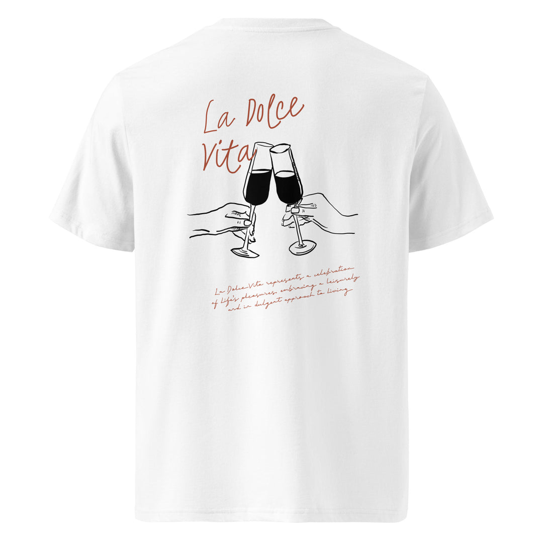 Introducing "The La Dolce Vita Organic T-shirt" by Tequila & Sunrise: a white unisex tee made from organic cotton, adorned with an artistic graphic of two hands clinking wine glasses and the vibrant red phrase "La Dolce Vita." It's an ideal choice for those passionate about sustainable fashion.